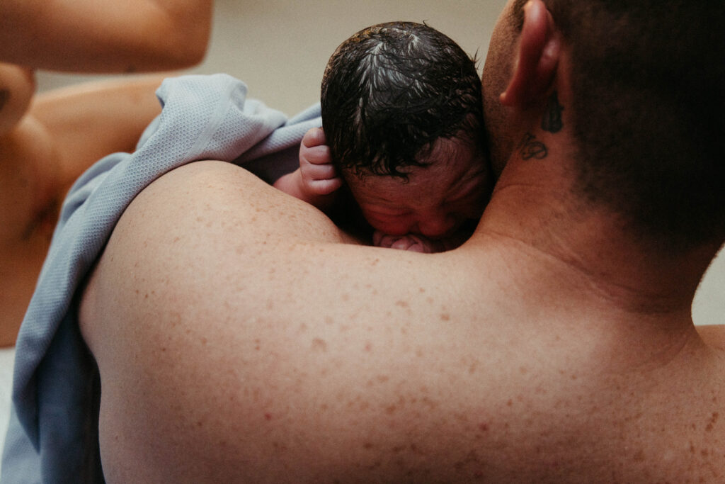 a Father cuddling his son for the first time 