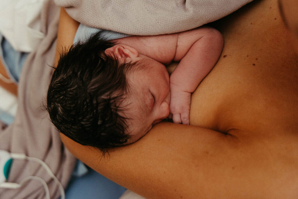 a woman breast feeding her son after birth