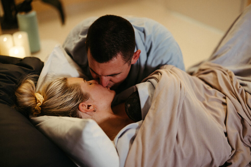 A husband kissing his wife after she gave birth with their son