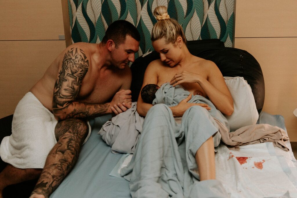 A mother holding her baby and the father next to them