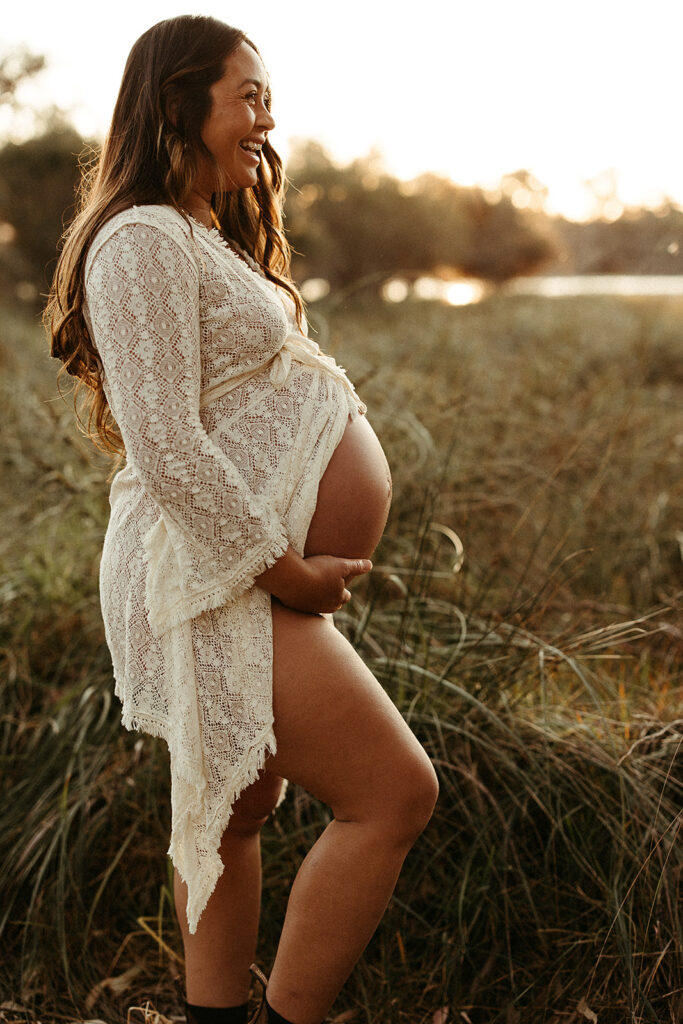 A pregnant woman showing her belly on a maternity shoot